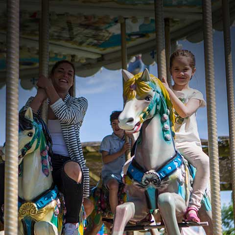 Mother and daughter on the horses of the merry-go-round.