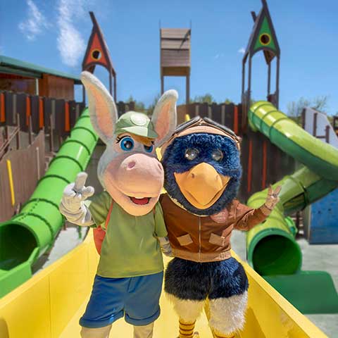 Sendaviva's mascots, Piko and Palmira the donkey, posing in front of the water slides of the Roko Urtsua attraction.