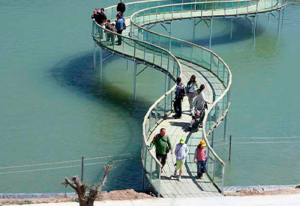 Familias cruzando la pasarela sobre el lago de Sendaviva.