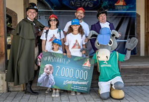 Foto de una familia ganando el premio a Visitante 2000000, junto a la antigua Burra Palmira.