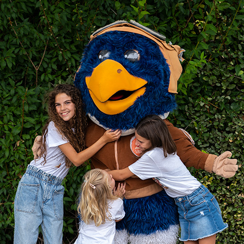 Three girls hugging Piko, one of Sendaviva's mascots.